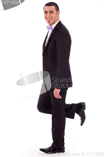 Image of Full length of a business man leaning against the wall