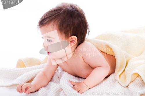 Image of Infant lying under the yellow towel