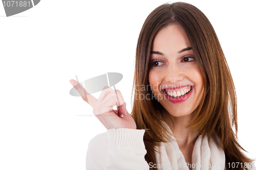 Image of attractive female model smiling and pointing her finger at copy space