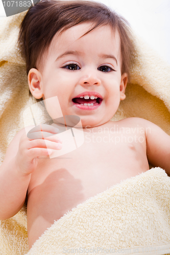 Image of Portrait of a happy baby wrapped in yellow towel