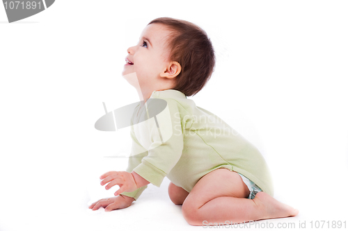 Image of Side pose of baby sitting and looking up