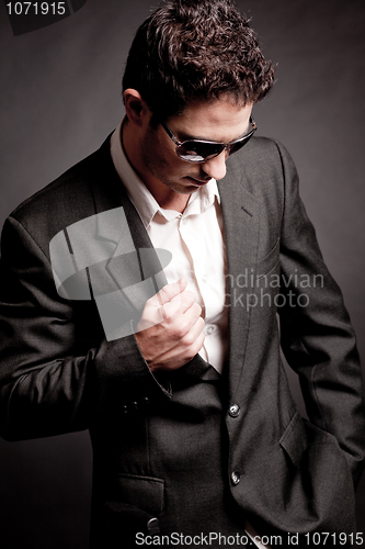 Image of Young business man looking down wearing sunglasses