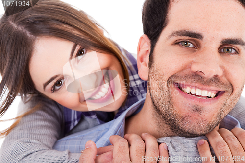 Image of Cute girl holding her hands round the neck of her boyfriend and smiling