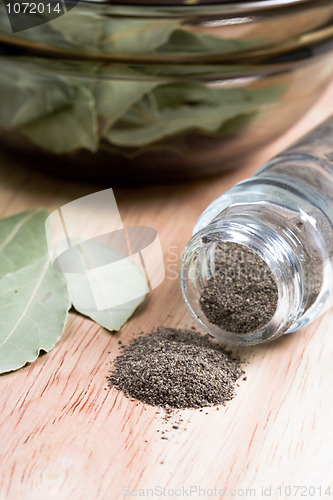 Image of black pepper in shaker and bay leaves