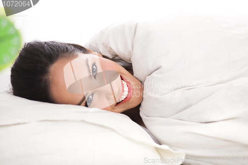 Image of Front view portrait of beautiful resting woman cover in white sheet