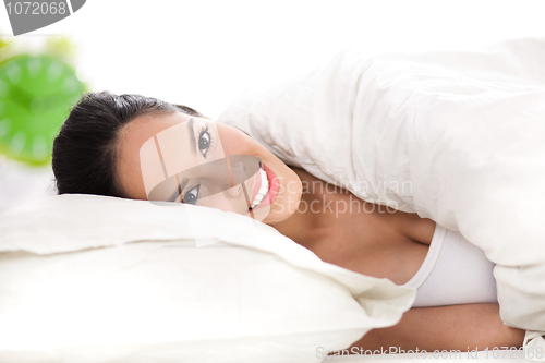 Image of Portrait of beautiful smiling woman on bed at bedroom