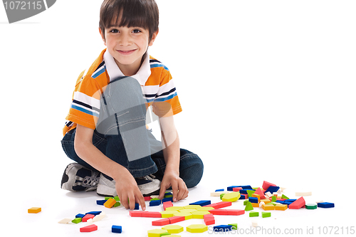 Image of Adorable caucasian boy joining the blocks while playing