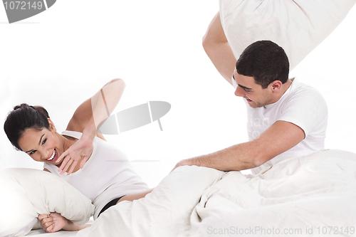 Image of Newly married young couple playing with pillows