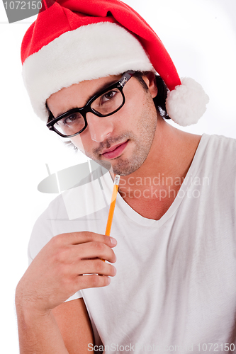 Image of handsome man thinking by wearing santa's hat