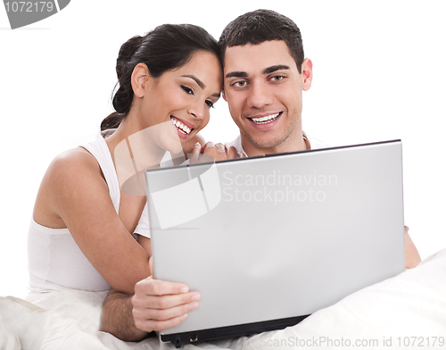 Image of Couple sitting in bed with laptop