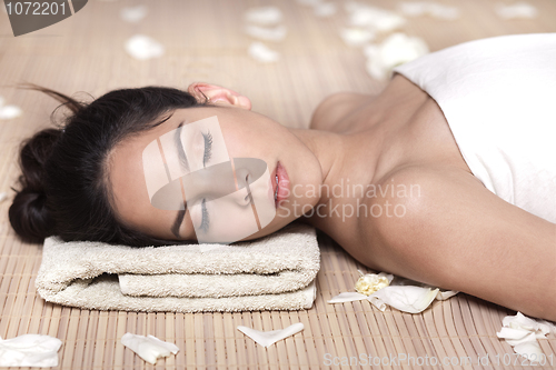 Image of Beautiful lady with white flowers in spa treatment