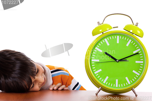 Image of Boy tired of study and sleeping near the clock