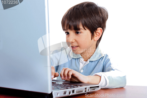 Image of Cute caucasian kid working in laptop
