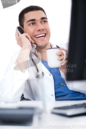 Image of Smiling young doctor over phone
