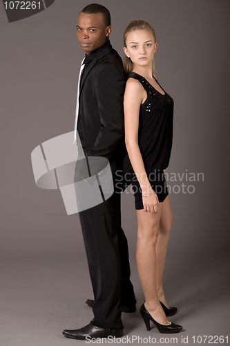 Image of Black man and white women standing back to back