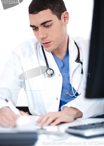 Image of Handsome doctor making notes from the computer