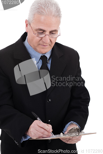 Image of Confident senior business man writing on the clipboard