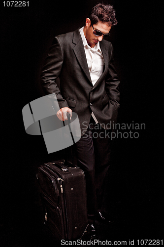 Image of Business man looking down with his luggage