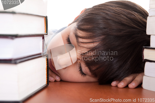 Image of School boy tired of studying and sleeping with books