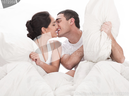 Image of Couple kissing and playing on bed in bedroom, in passion