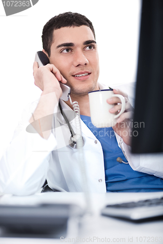 Image of Portrait of young doctor talking over telephone and having coffee