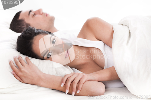 Image of Couple in bed, men sleeping and woman lying sleepless