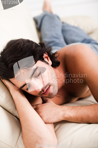 Image of young man relaxing in the sofa