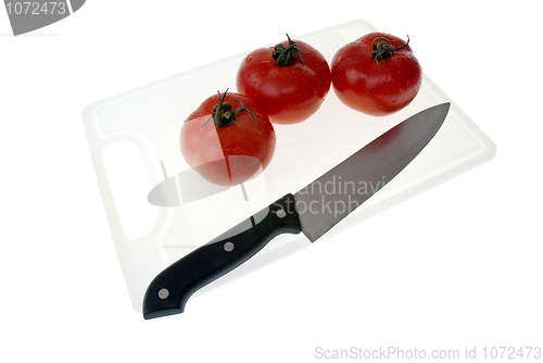 Image of Cutting board with a knife and tomato