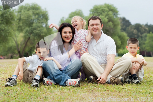 Image of Portrait of happy family of five on the green land