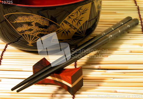 Image of  Wooden bowl and chopsticks on a bamboo straws floor