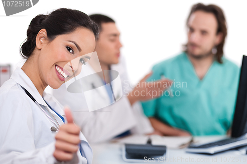 Image of Asian women doctor show ok sign, two other team mates talking deeply