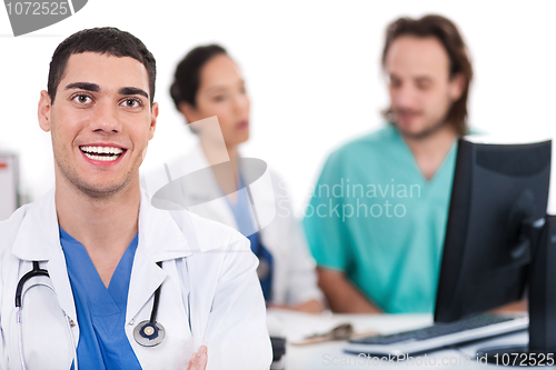 Image of Happy young doctor in focus, two others in out of focus