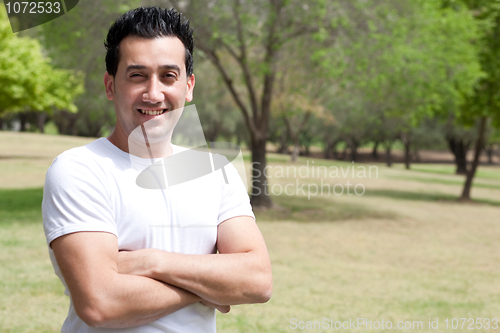 Image of young man with his hands folded in the park