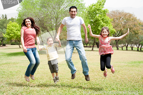 Image of Family jumping together in the park