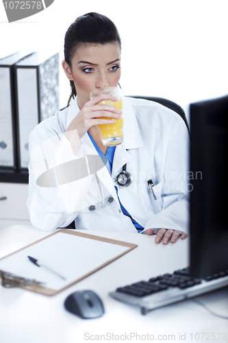 Image of Doctor drinking a glass of juice at her workplace