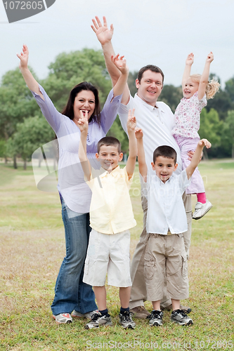 Image of Happy family on outdoors  enjoying by raising hands