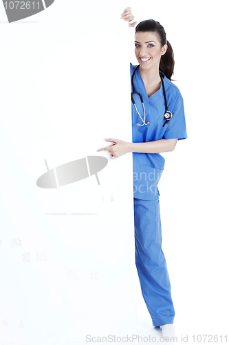 Image of Smiling young nurse pointing blank board
