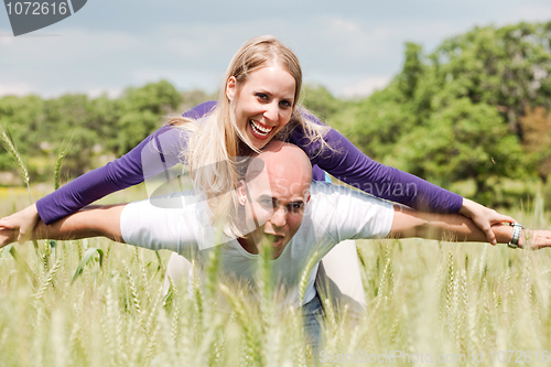 Image of Teenage couple with the lady piggybacking on handsome young man