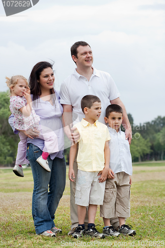 Image of Happy family with three kids looking away with curiosity