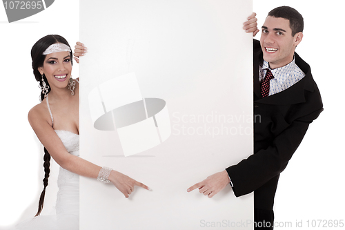 Image of Bride and groom pointing at blank board