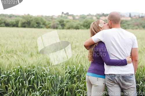 Image of Rear view of couple, girl kissing the male