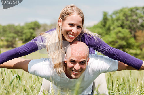 Image of Young man giving shoulder ride to her girlfriend