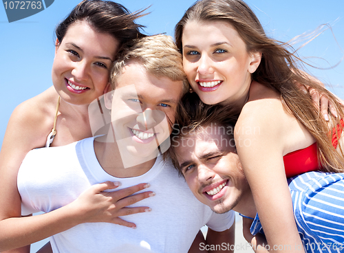 Image of Two Young man giving piggyback to their girlfriends