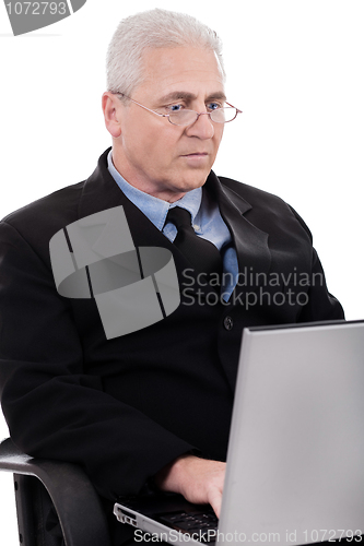 Image of Mature business man busy working in notebook
