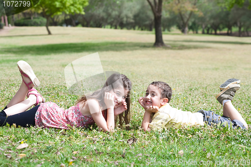 Image of Cute children lie down on green grass