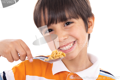 Image of Smiling young boy with spoon of flakes, closeup