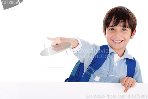 Image of Smiling young boy standing behind the blank board and pointing us