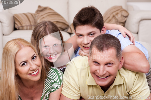 Image of Smiling family lying together on the floor