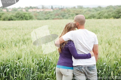 Image of Rear view of couple with arms around each other