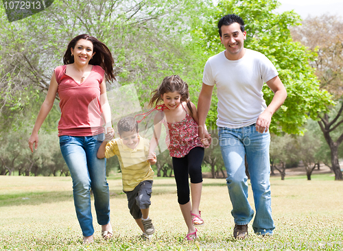 Image of Family running on green grass field